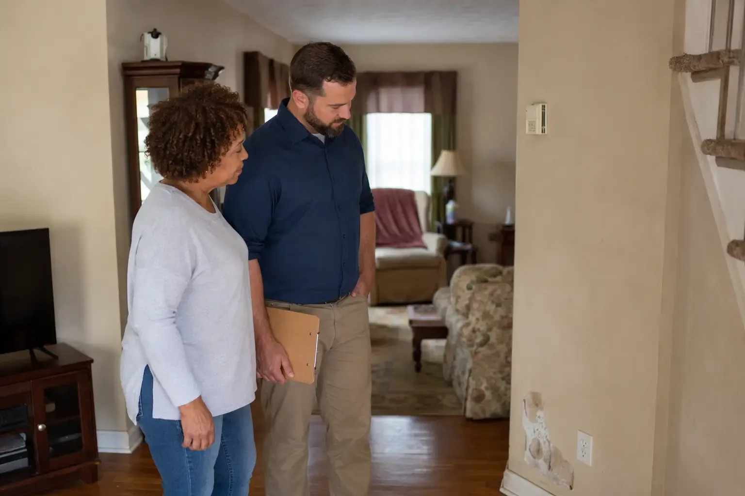 Two people reviewing wall damage during a walk-through