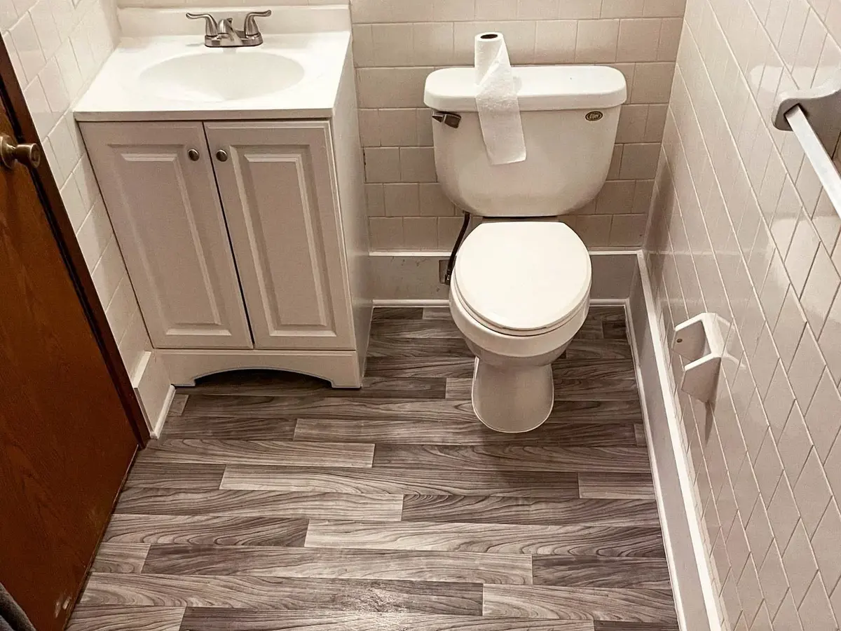 A compact bathroom with newly installed sheet flooring