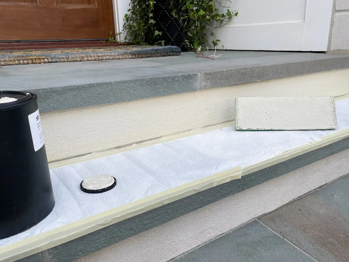 Exterior front steps masked and prepared during a concrete and finish repair